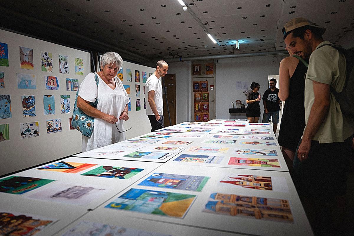 Visitors looking at the exhibition of drawings by the visual arts students